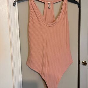 Free People Dusty Rose Ribbed Racerback Bodysuit. Color pale rose.